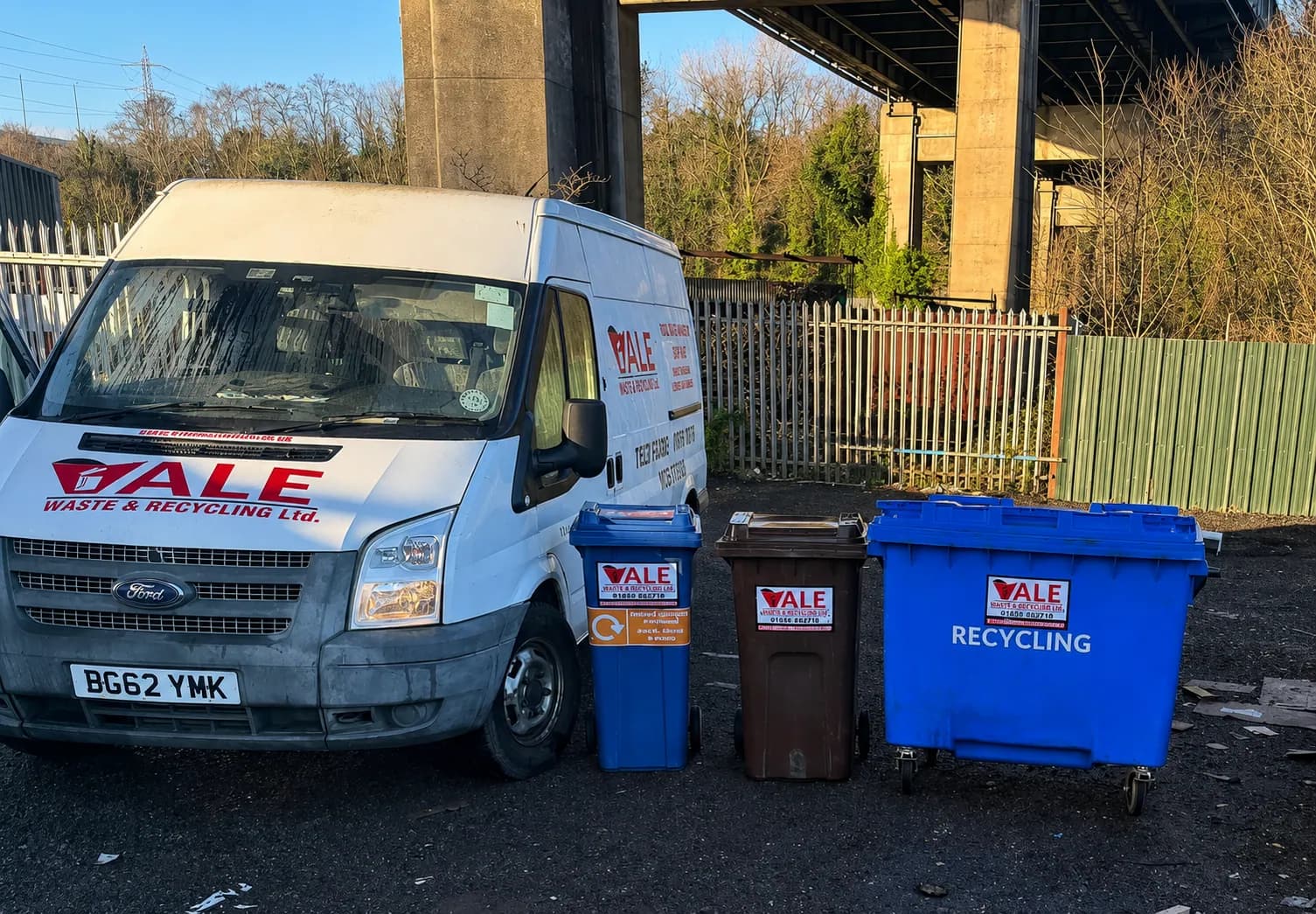 Trade bins lined up beside a Vale Waste Neath van at Jersey Marine