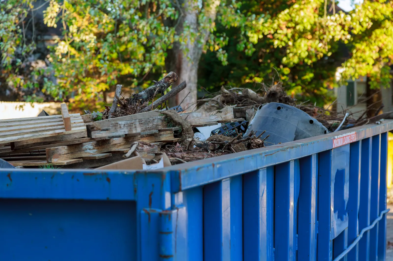 A loaded skip of timber, pallets and green waste